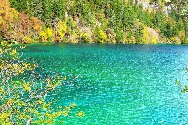 Màu nước xanh ngọc bích lấp lánh, phản chiếu bầu trời và những rặng núi cao vút